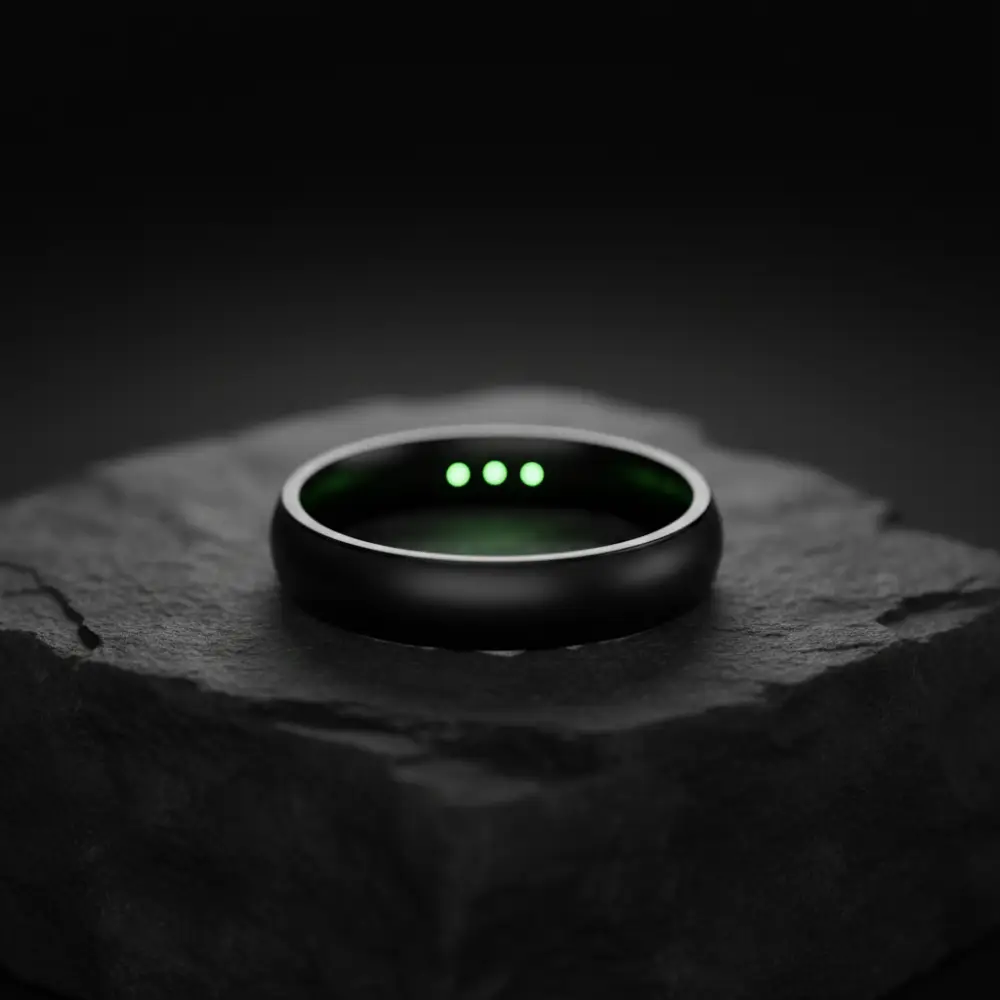 Anillo inteligente negro Oura Ring con sensores biométricos verdes visibles en el interior.
