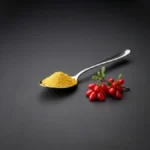 Cuchara con polvo de berberina pura de color amarillo brillante junto a una rama natural de Berberis vulgaris.